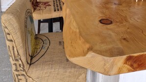 A wooden bar area with a rustic design, including burl chairs and a cactus decoration.