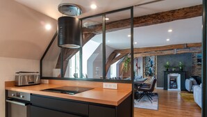 Una cocina moderna con encimera de madera, horno integrado y un amplio ventanal.