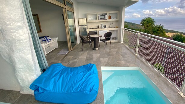 A balcony with a pool, a dining area, and a kitchen. - Ninamu Pearl  Guest House (Punaauia)