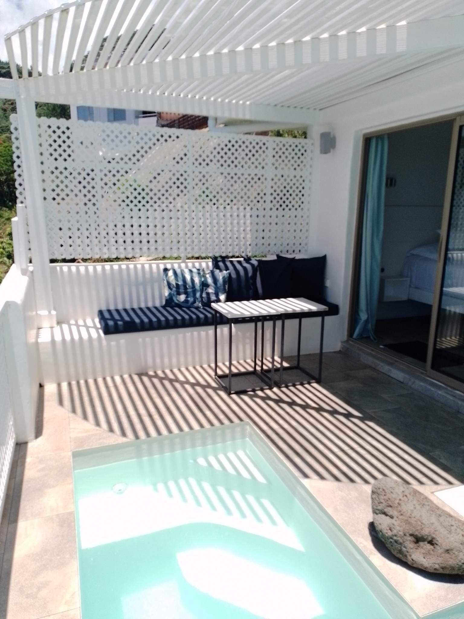 Un espace extérieur aménagé, abrité et doté d’une table de billard, d’un canapé avec des coussins et d’une table de piscine avec un plateau en verre.