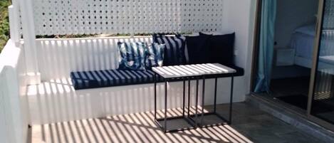 Un espace extérieur aménagé, abrité et doté d’une table de billard, d’un canapé avec des coussins et d’une table de piscine avec un plateau en verre.