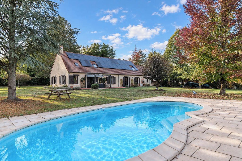 Una casa con piscina, paneles solares y una mesa de picnic.