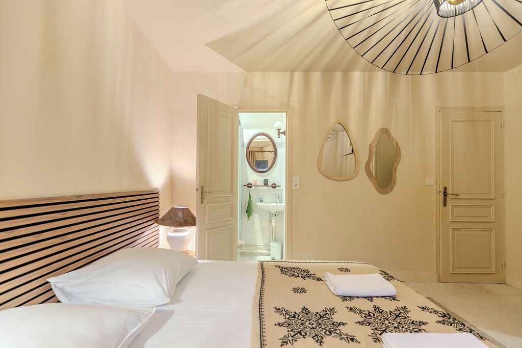 Ein Hotelzimmer mit einem Bett, einem Nachttisch, einem Spiegel und einer Tür.