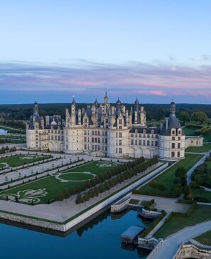 A grand château with multiple towers and a symmetrical garden layout, including a central fountain and manicured lawns. - Chambord - Beautiful residence (12 pers) with private park and swimming pool (Thoury)
