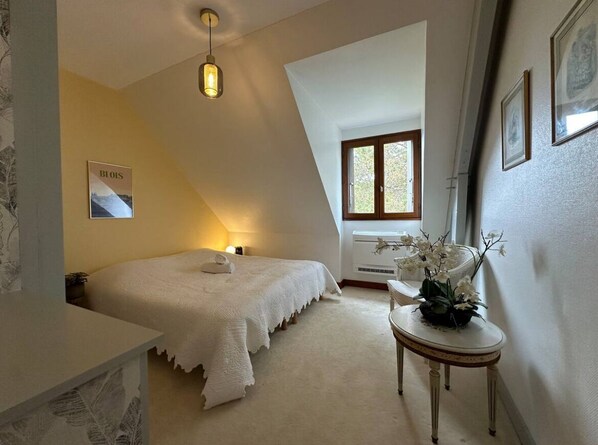 A bedroom with a bed, a bedside table, a lamp, a window, and a wall-mounted picture. - Chambord - Beautiful residence (12 pers) with private park and swimming pool (Thoury)