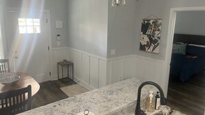 Een keuken met een marmeren aanrecht, een spoelbak en een eethoek met een tafel en stoelen.