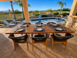 An outdoor dining area with a pool, chairs, and a table set for six. - Scottsdale Area Resort Oasis - Heated Pool, Spa, Putting Green & Panoramic Views (Fountain Hills)