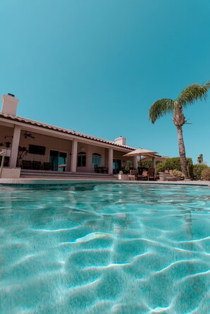 A clear swimming pool with a house in the background. - Scottsdale Area Resort Oasis - Heated Pool, Spa, Putting Green & Panoramic Views (Fountain Hills)