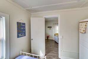 Ein Zimmer mit einem Bett, einer Tür zu einem anderen Raum und einem motivierenden Spruch an der Wand.