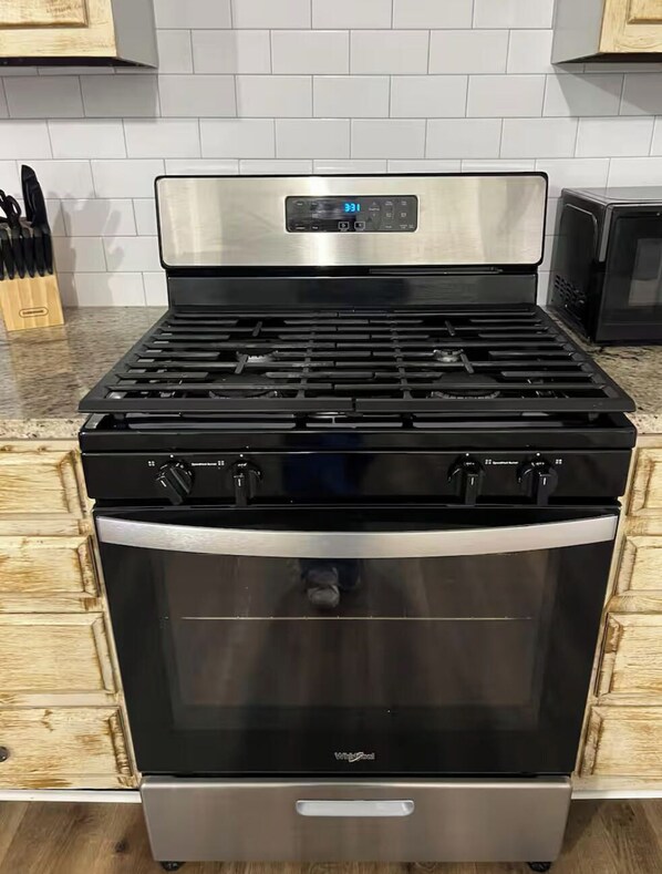A stainless steel stove with a digital display, a stainless steel oven, and a wooden cabinet. - Hayden House
3 bedroom/2 bathroom/ 3 beds (Vernon)
