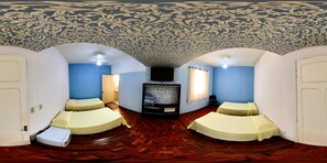 Una camera con due letti, televisione e un soffitto decorato.