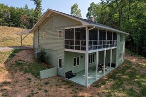 A two-story house with a covered porch and a large windowed front section. - Longview - Woodburning fireplace (Hayesville)
