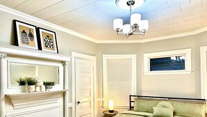 A bedroom with a bed, a nightstand, a mirror, a fireplace, and a ceiling fan. - Family Retreat - Stunning 5BR-2BA with Parking/ Near Savin Hill Station (Boston)