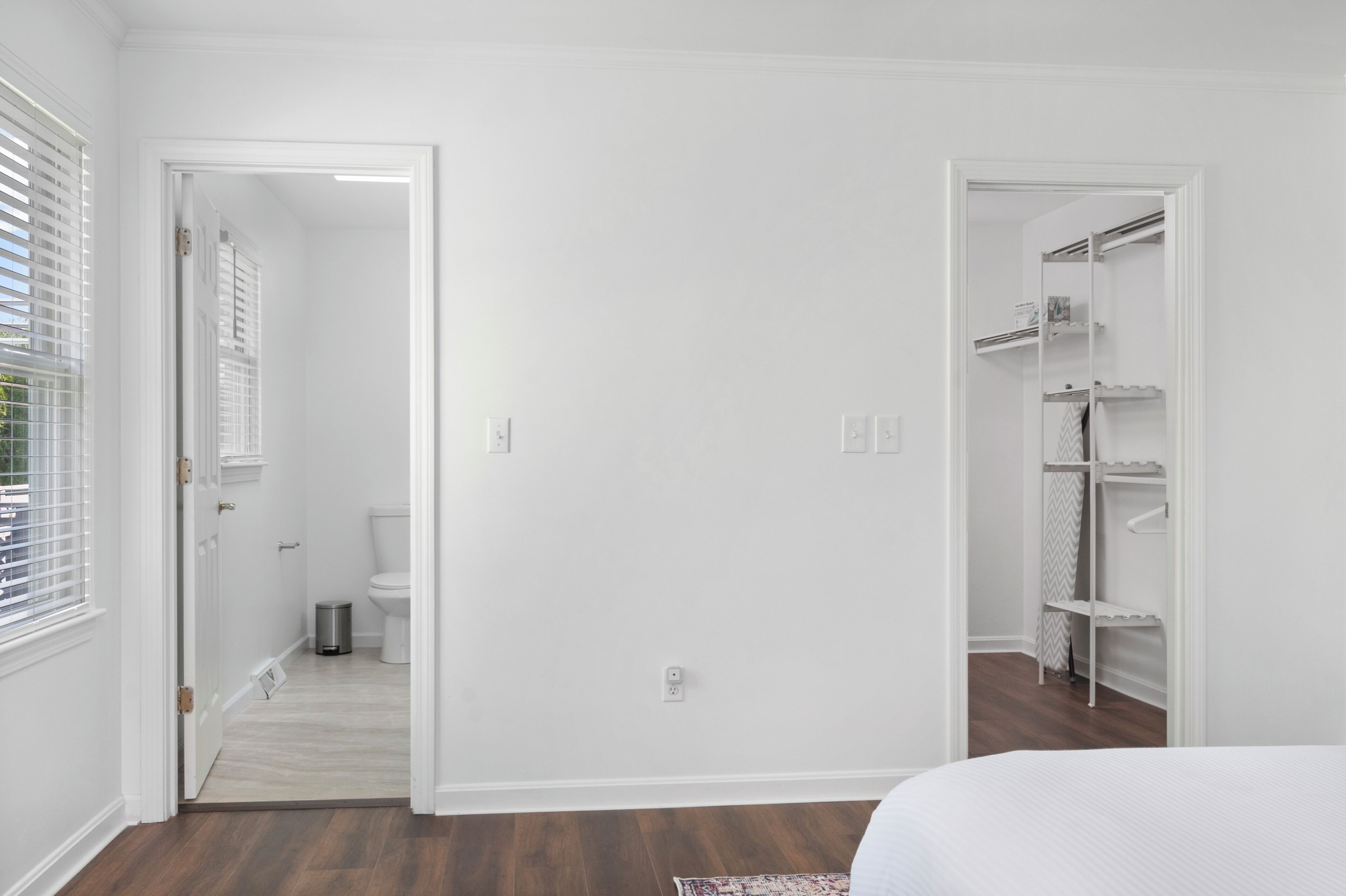 Una camera da letto con un letto, un armadio e un bagno con il water e il lavandino.