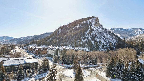 A ski resort with a prominent mountain, buildings with snow-covered roofs, and a clear sky. - Ascent 108 - 2 Bedroom Residence (Avon)