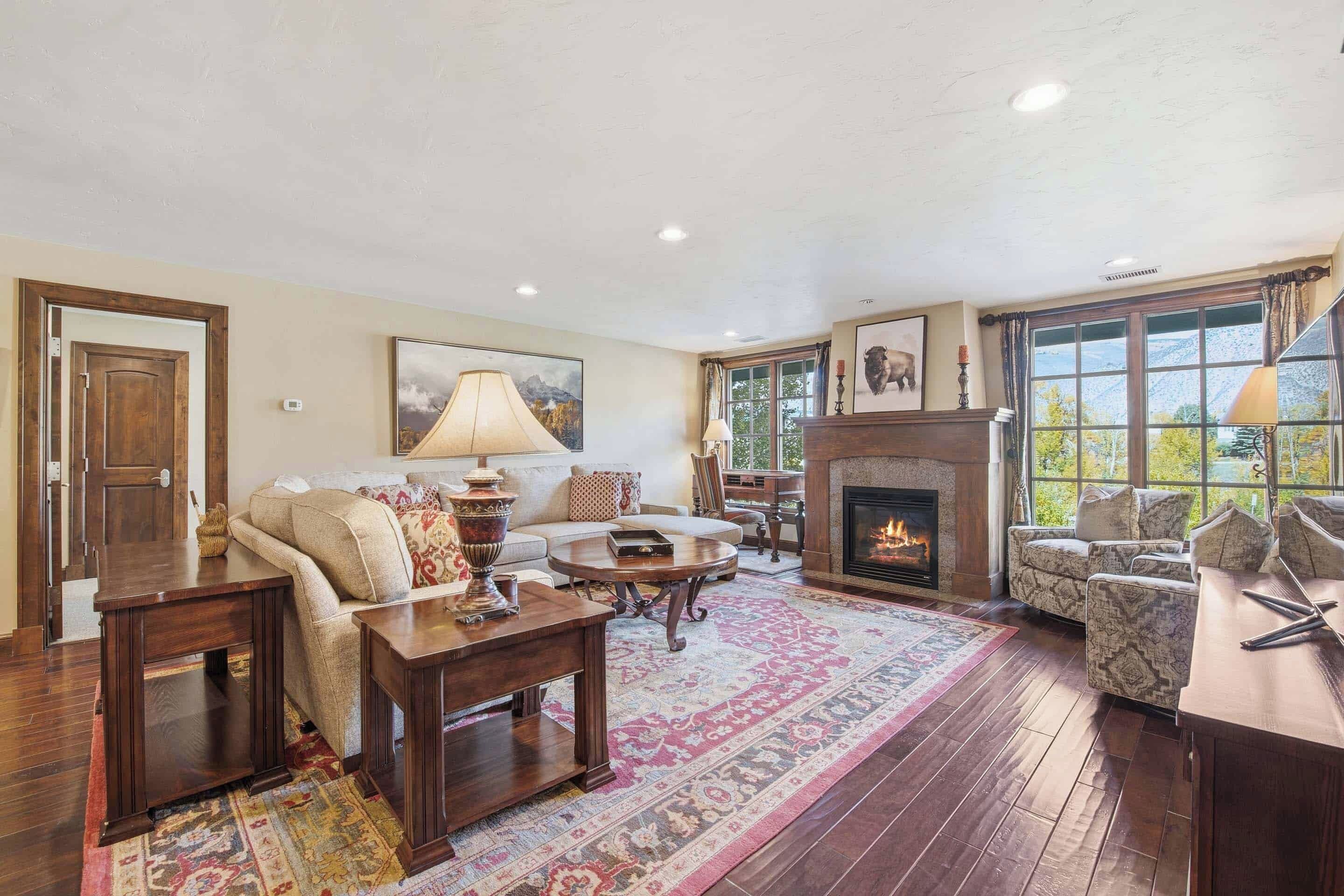 A cozy living room with a fireplace, a sofa, a coffee table, and a rug.
