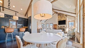 A spacious living area with a round white table, fluffy chairs, and a large white lamp.