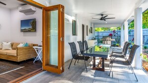 A modern living room with a glass door leading to a patio area.