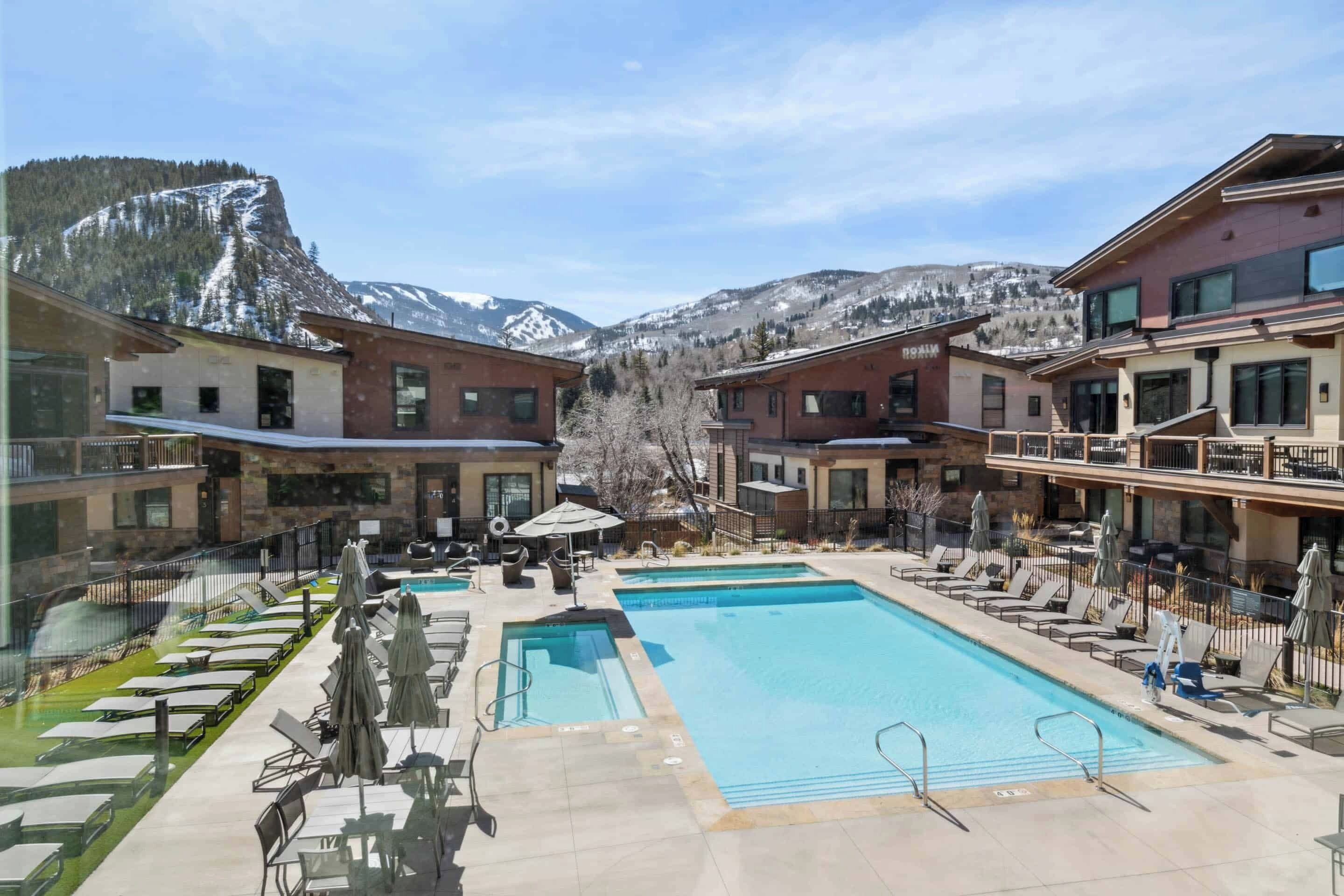 Un hôtel doté d'une piscine, d'un espace extérieur aménagé et offrant une vue sur les montagnes.