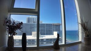 A large window with a view of a modern building and the ocean. - Two Bedroom Penthouse with Large Balcony overlooking the Ocean spectacularview (Fort Lauderdale)