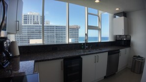A modern kitchen with a large window, stainless steel appliances, and a view of a cityscape. - Two Bedroom Penthouse with Large Balcony overlooking the Ocean spectacularview (Fort Lauderdale)