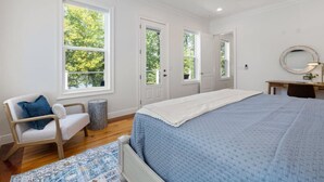 Un dormitorio con cama, una silla, un escritorio y un ventilador de techo.