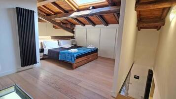 Een slaapkamer met een houten plafond, een bed met een blauwe deken en een radiator aan de muur.