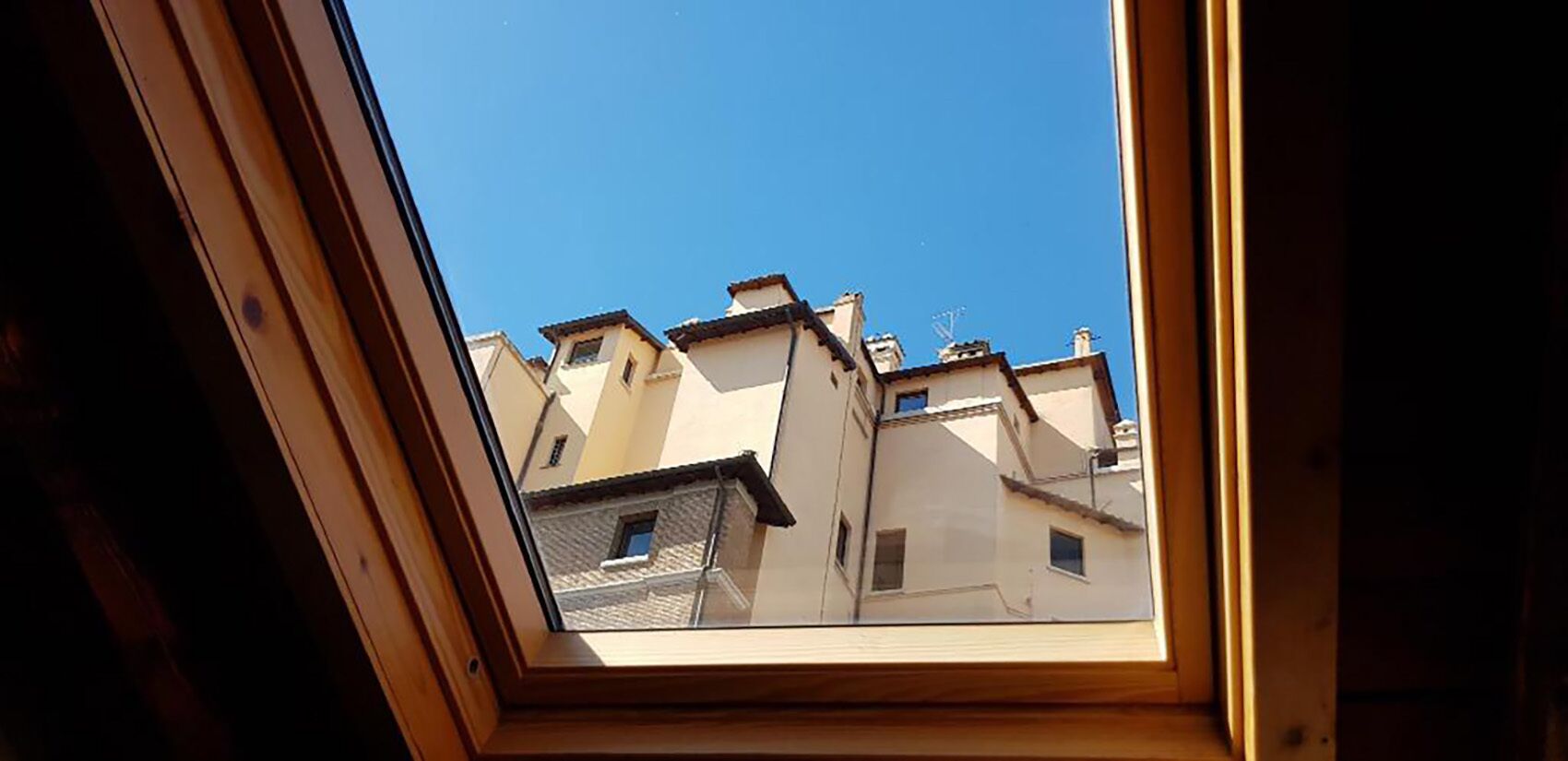 Vue sur un quartier résidentiel avec de nombreux immeubles, prise à travers un puits de lumière.