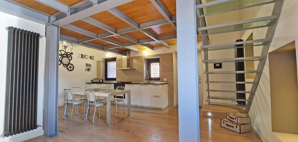 Een moderne keuken met witte kasten en een eethoek met een tafel en stoelen.