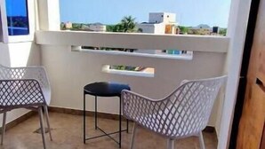 A balcony with two chairs and a table, a clear view of the cityscape, and a tiled floor. - Jungle Sensation (Lomé)
