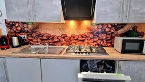 Una cucina con gas, un forno a microonde e una macchina per il caffè.