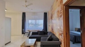 A modern living room with a sofa set, a coffee table, and a dining area with a table and chairs. - Casa D´Oro (Lomé)