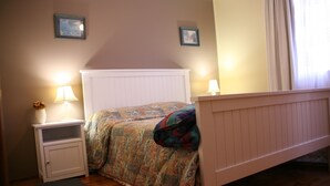 A bedroom with a bed, nightstand, and two wall-mounted lamps. - Welcoming 2-bedroom apartment in The Entrance (The Entrance)