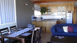 A compact living space with a dining area, a kitchenette, and a seating area with a sofa. - Welcoming 2-bedroom apartment in The Entrance (The Entrance)