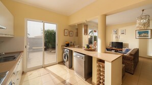 Una cocina compacta equipada con lavavajillas, lavadora y comedor con mesa y sillas.