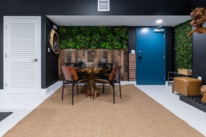 Un área de comedor con una mesa redonda, sillas y un centro de mesa decorativo con un tronco de árbol.
