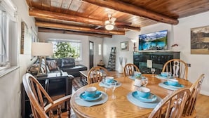 A dining area with a wooden table set for four, surrounded by wooden chairs. - Pickleball Retreat | Hot Tub & Games (Denver)