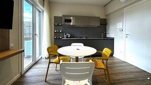 A modern kitchen with a microwave, stove, and sink. There is a dining table with four chairs. - Skyline-Sunshine ( Apartment with terrace) (Siena)