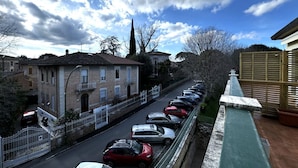 A residential street with parked cars, a row of houses, and a clear sky. - Skyline-Sunshine ( Apartment with terrace) (Siena)