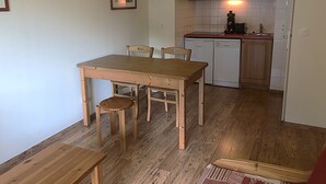 A compact kitchen with a wooden table and chairs, a dishwasher, and a microwave. - Terrasses F 102 - PARC NAT. VANOISE appart. 4 pers (Val Cenis)