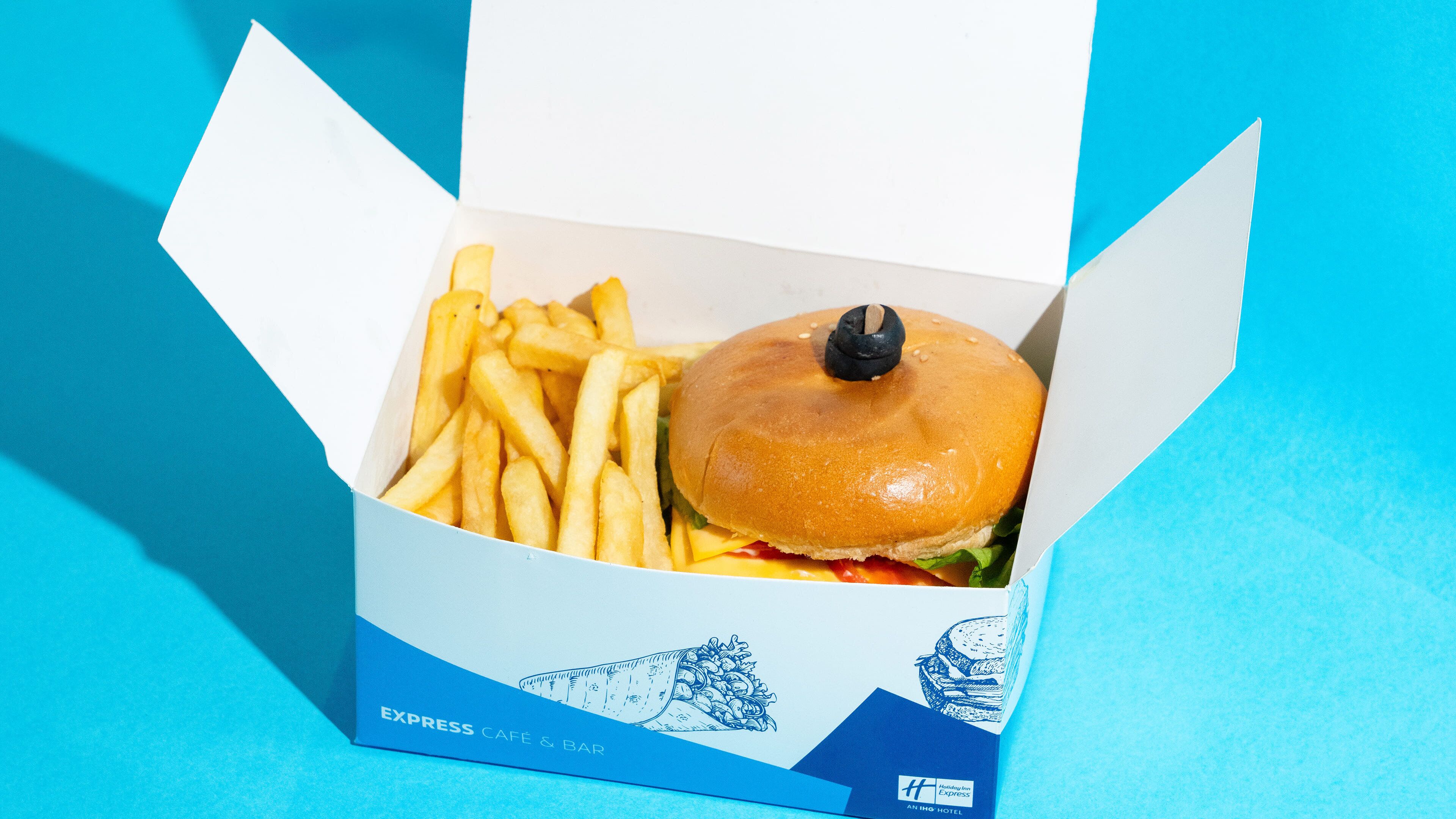 A box containing a burger and fries, labeled 'EXPRESS CAFE & BAR' with a logo of a building and 'Holiday Inn Express' at the bottom.
