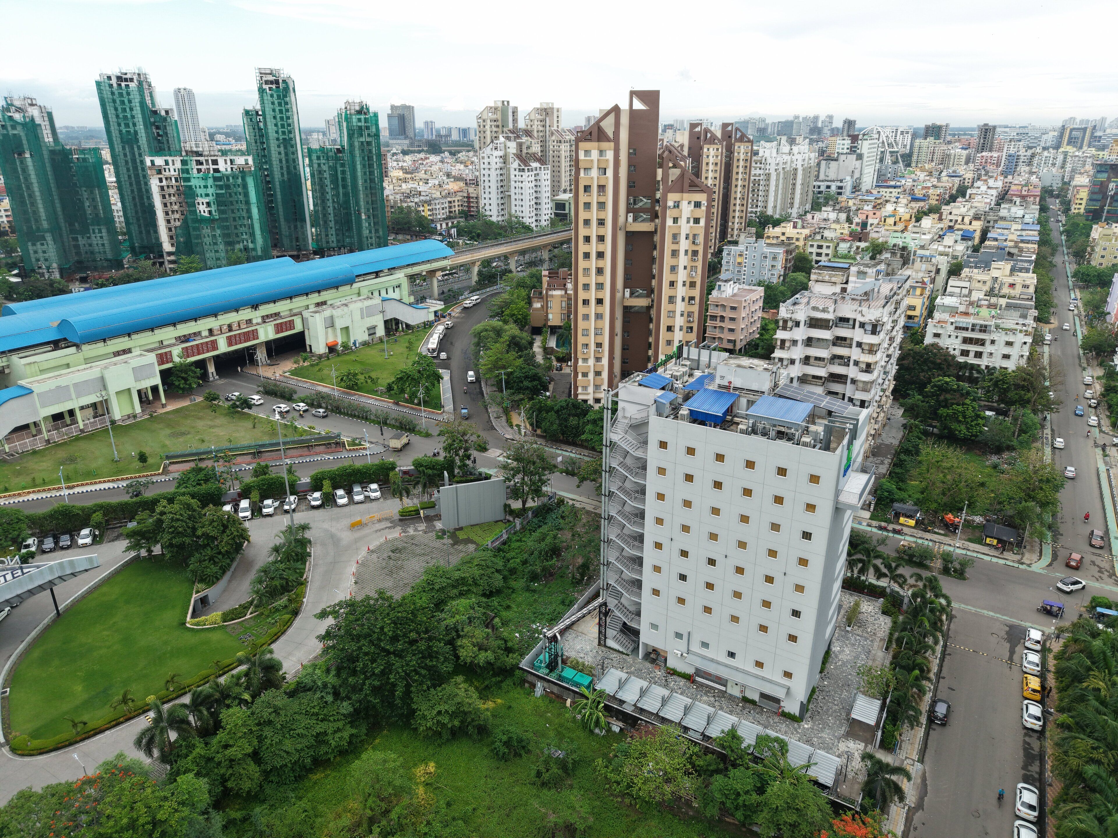 A high-rise building with a modern design, surrounded by a mix of residential and commercial buildings.