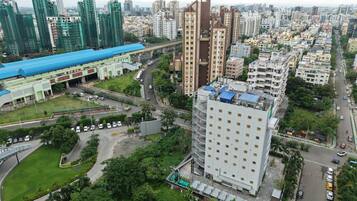 A high-rise building with a modern design, surrounded by a mix of residential and commercial buildings.
