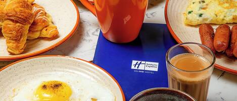 A breakfast spread with various dishes including eggs, toast, soup, and pastries.