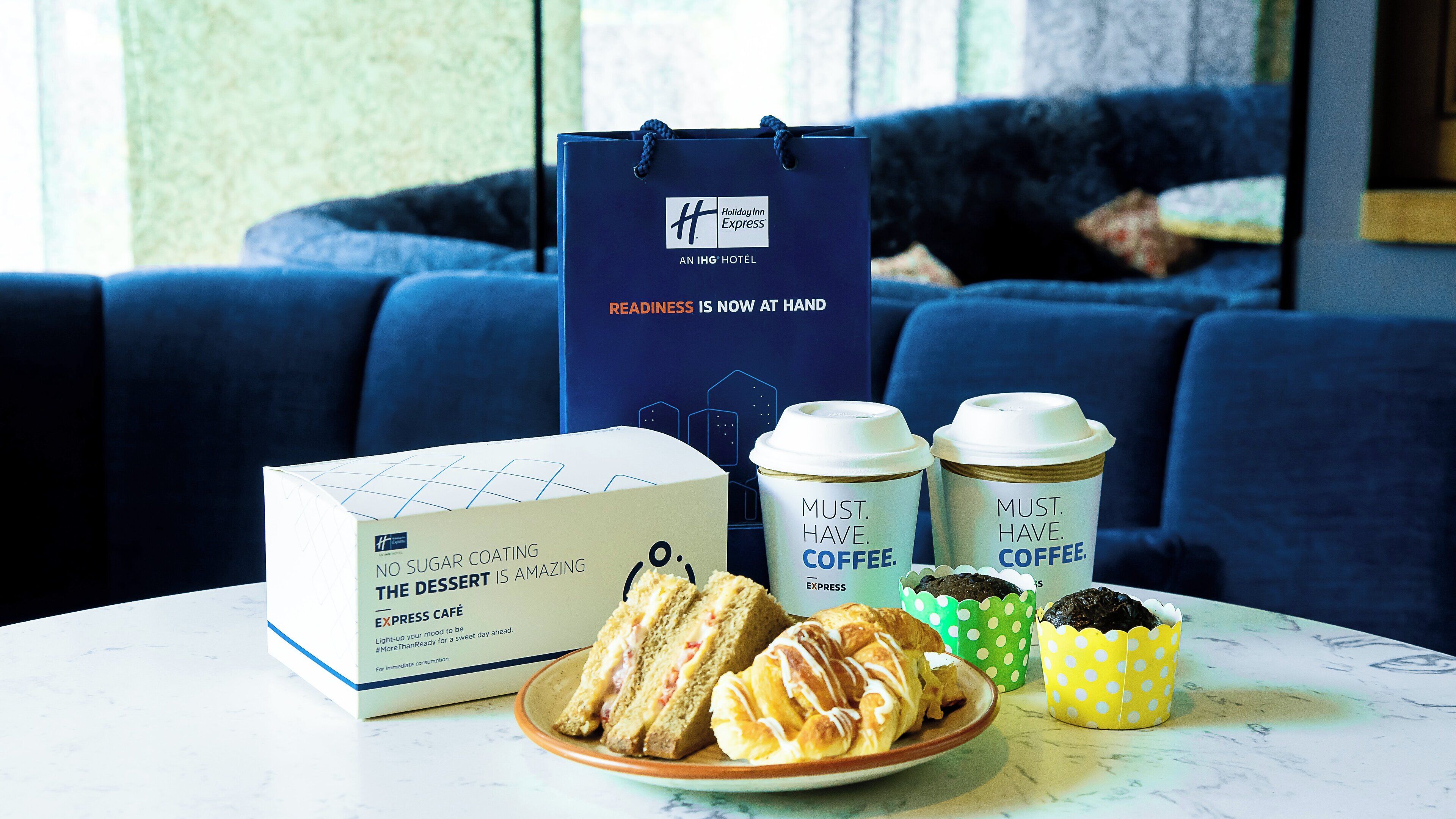 Ein Tisch mit einer Dessertbox, zwei Kaffeetassen und Gebäck.