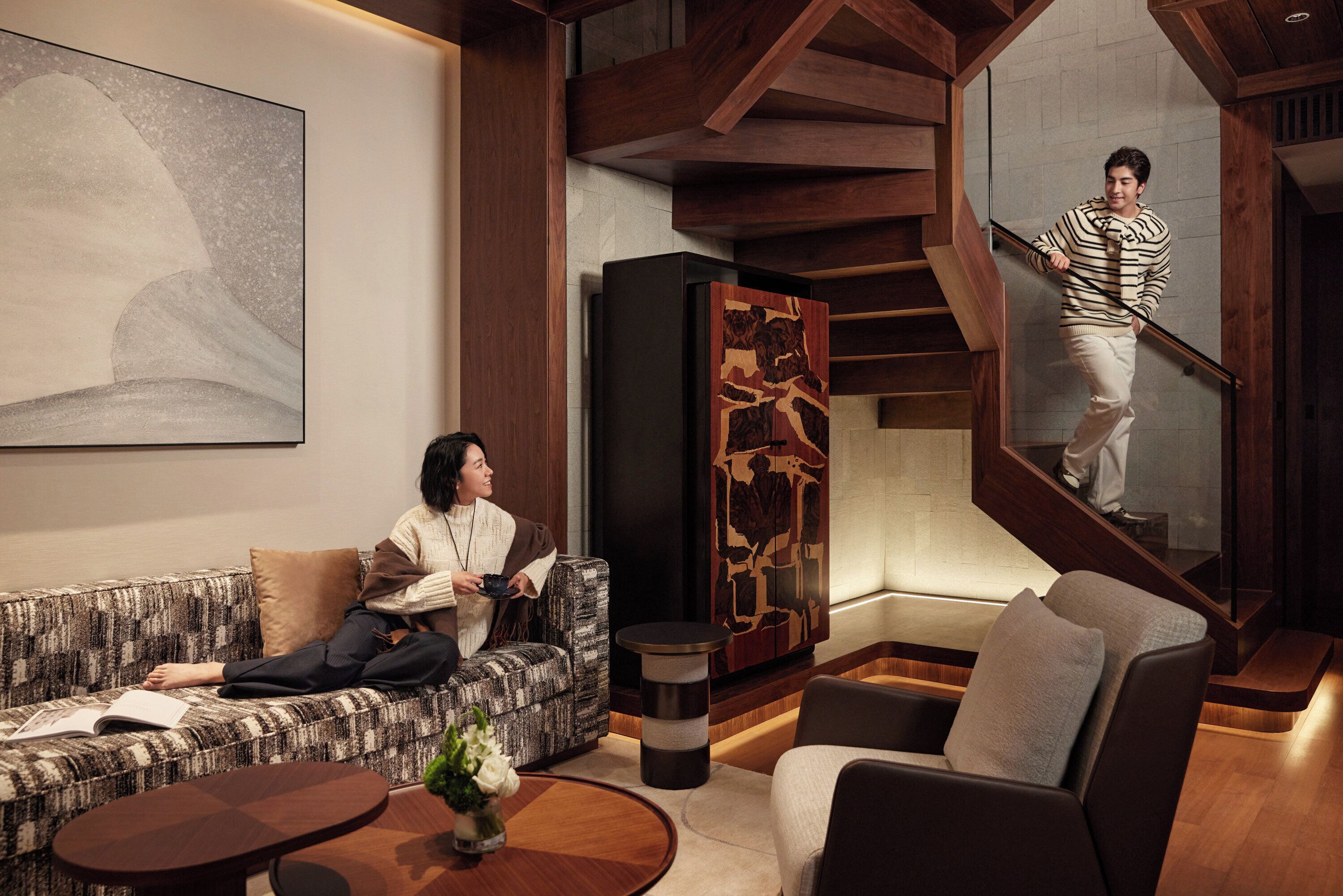 Un intérieur moderne avec un canapé, une table basse et un escalier.