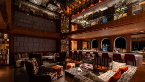 A bar area with high stools, a bar counter, and a seating area with sofas and chairs. - Shanghai Snow World Hotel, Vignette Collection by IHG (Shanghai)