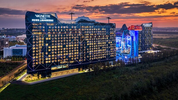 A modern hotel complex with multiple buildings, including a prominent one with a grid-like facade and illuminated windows. - Shanghai Snow World Hotel, Vignette Collection by IHG (Shanghai)