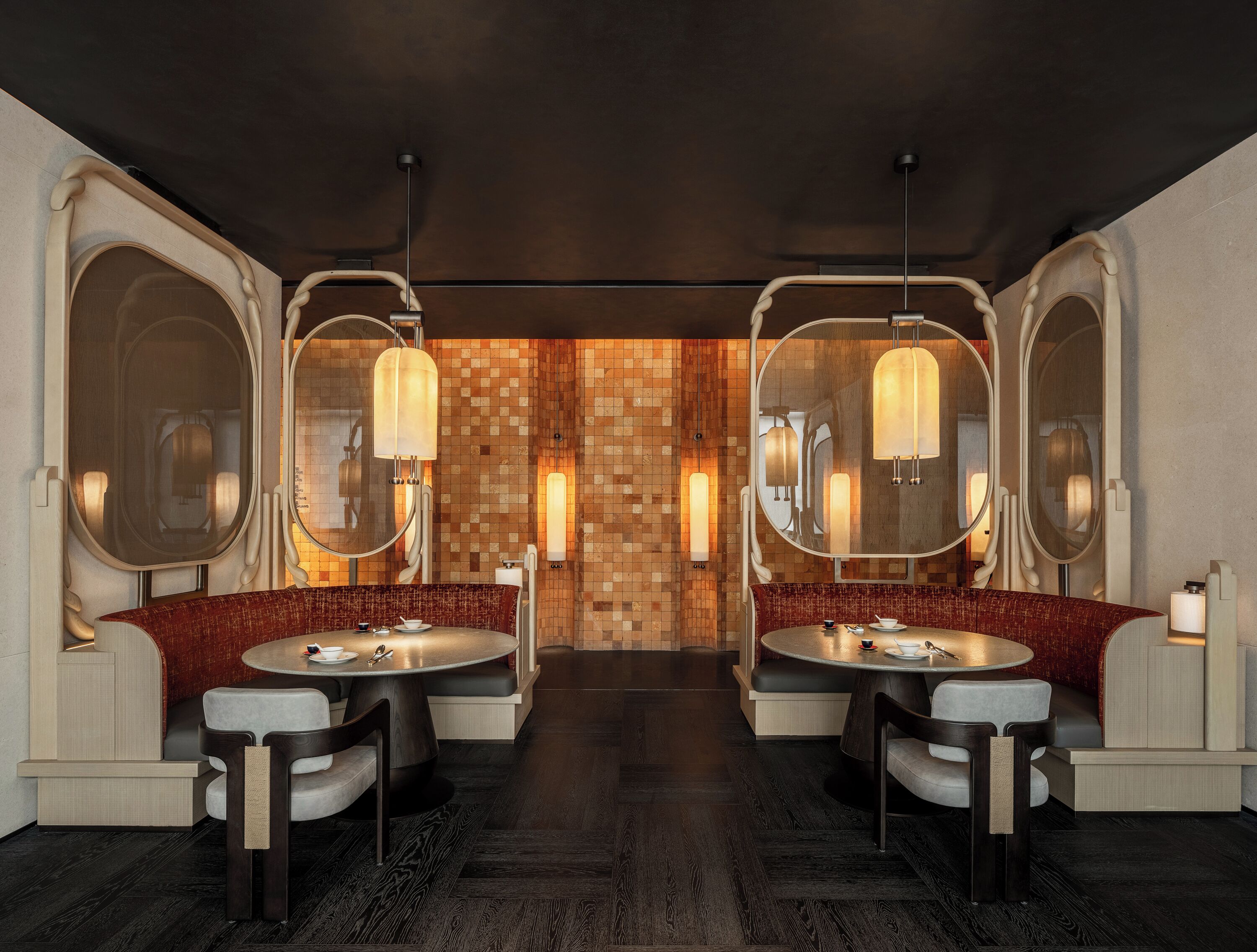 A modern bathroom with two sinks, large mirrors, and a central wall with a mosaic pattern.