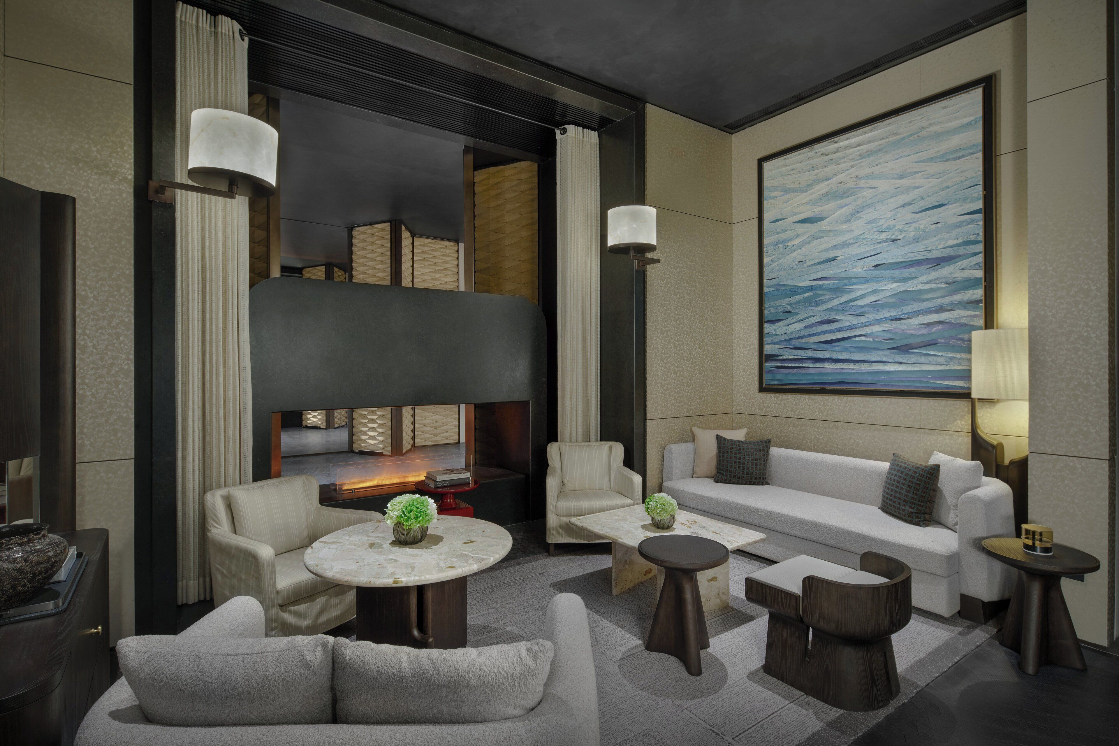 A modern lounge area with a sofa, armchairs, and a fireplace.